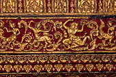 Wat Xieng Thong temple in Luang Prabang, Laos. Gilded carvings on a red background decorating the interior of the sim. 